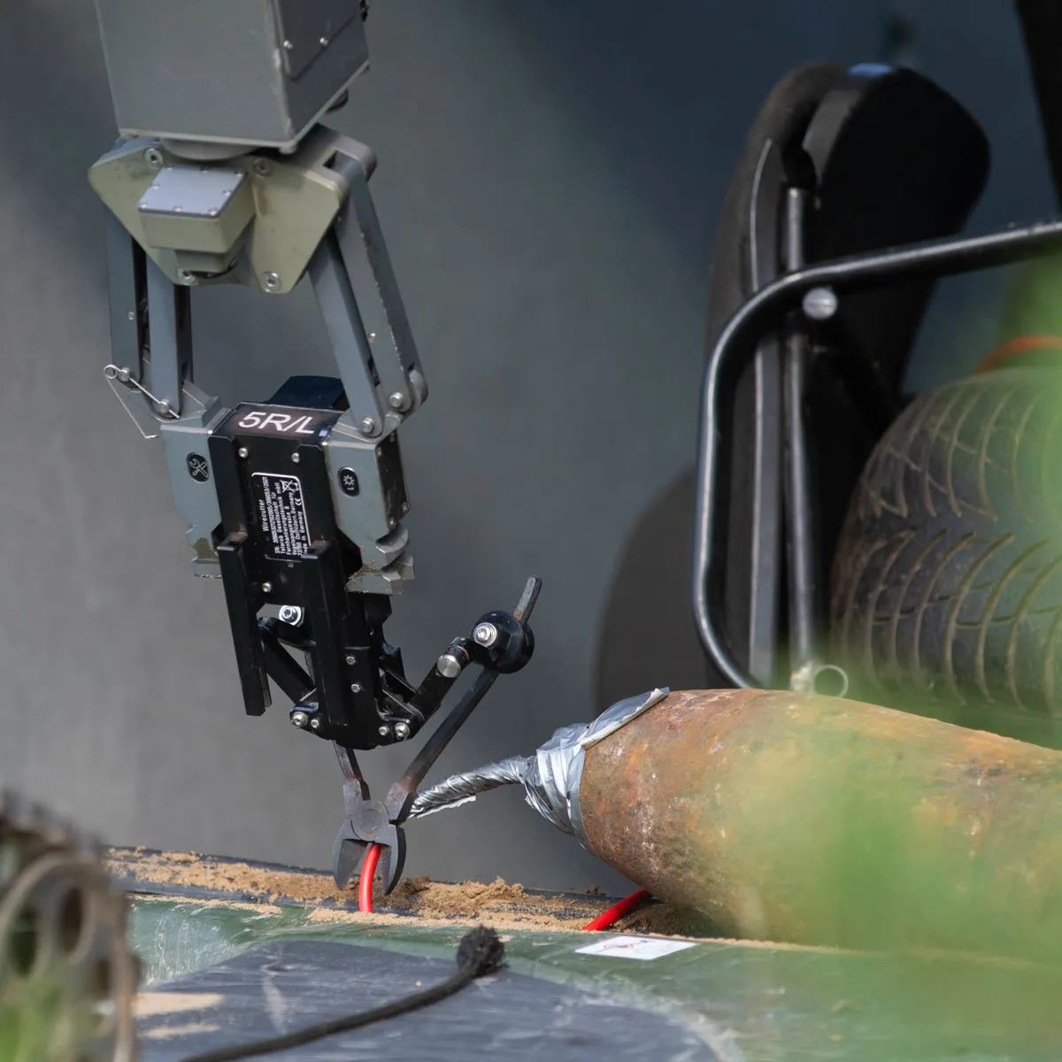 A robotic manipulator arm cutting a wire on an improvised device during a bomb disposal exercise.